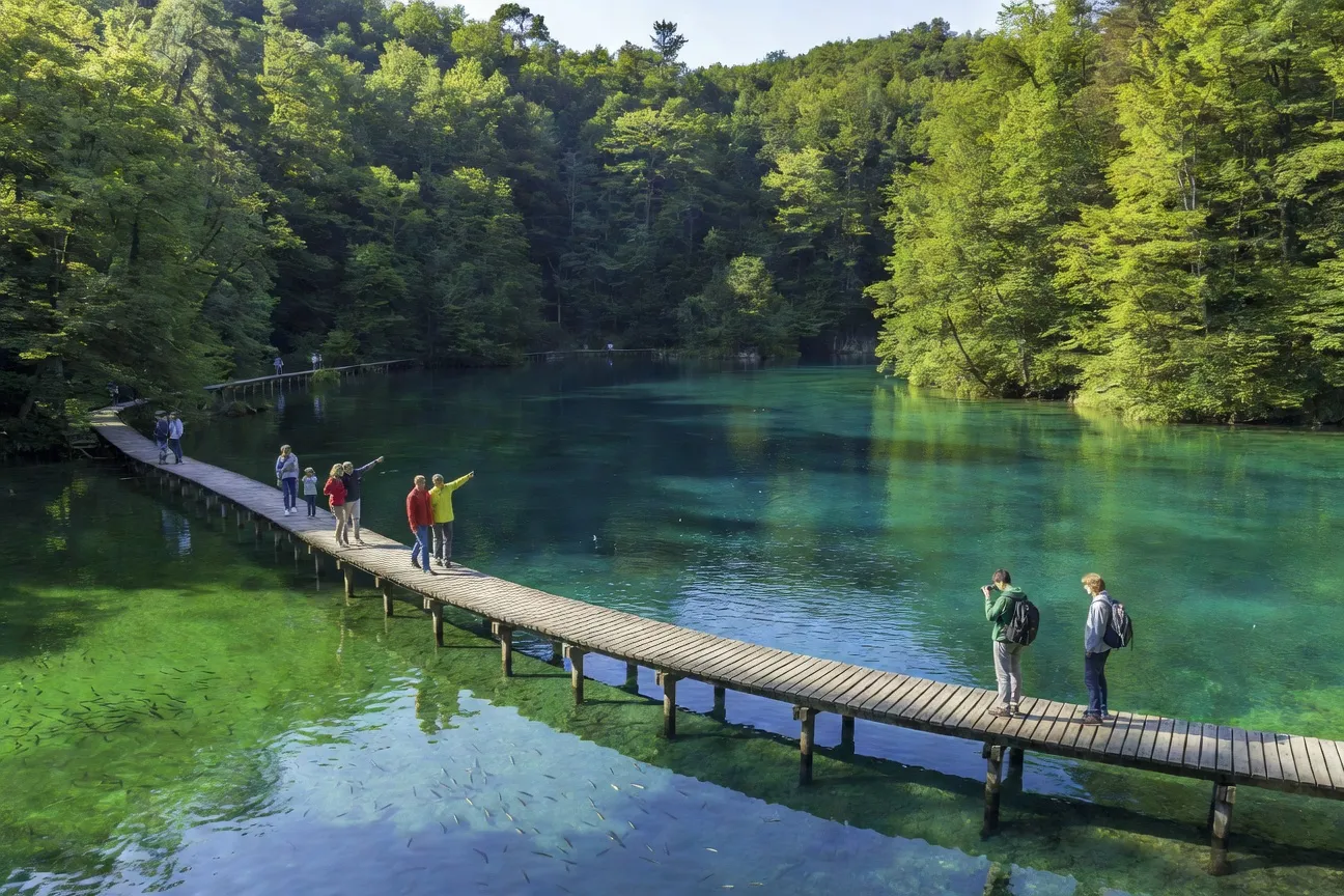 Passerelles en bois sur les lacs turquoise de Plitvice avec touristes en file